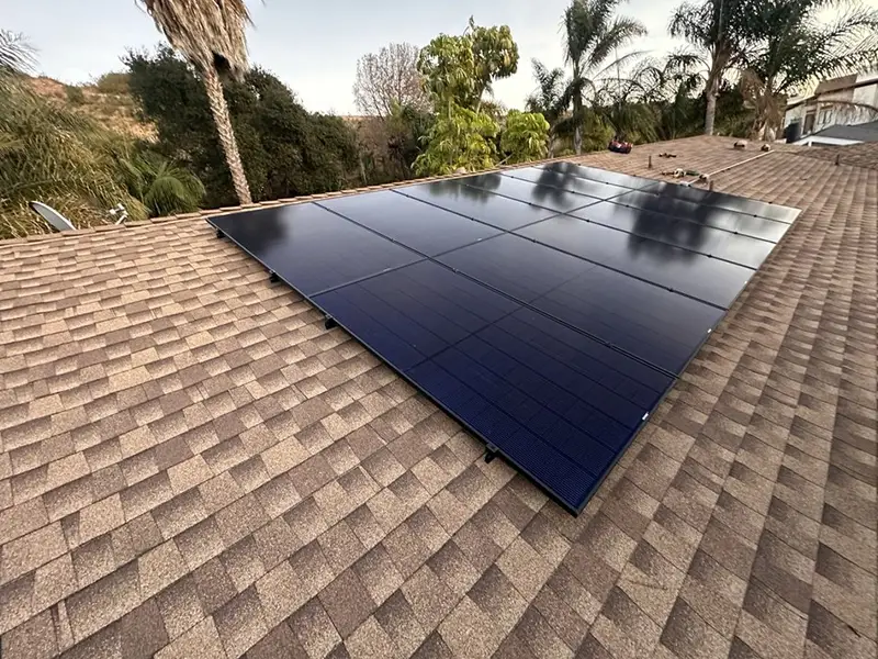Solar Panel Installations on a Tiled Rooftop Surrounded by Trees